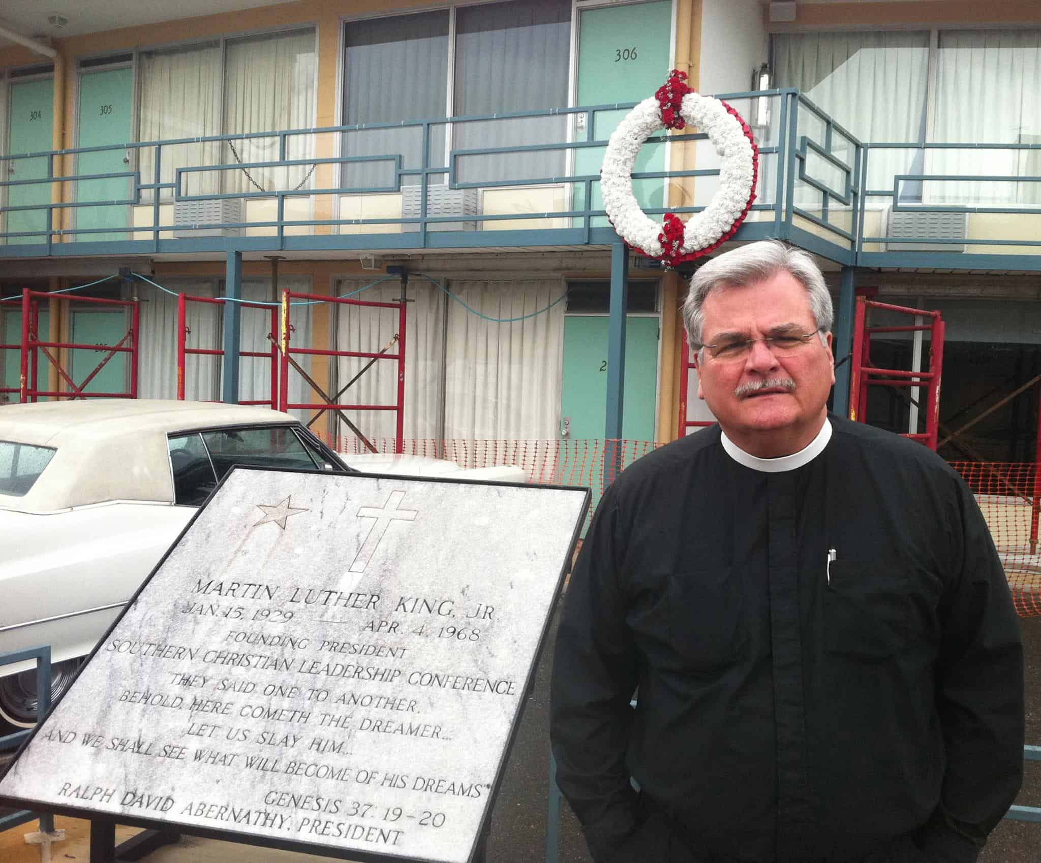 Pastor in his collar standing at the plaque commemorating the location where Martin Luther King Jr. was assassinated.