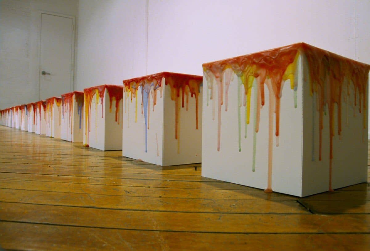 The Knowledge Series by Rondall Reynoso consists of a row of white wooden boxes with painted tops in shades of red that drip over the sides. Knowledge Series, 2004