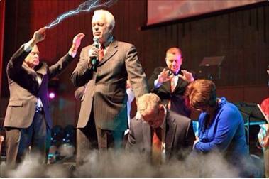 Darth David Hankins laying hands on joe Aguillard to pray with smoke in the foreground and another minister shooting sith force lightning out of his hands