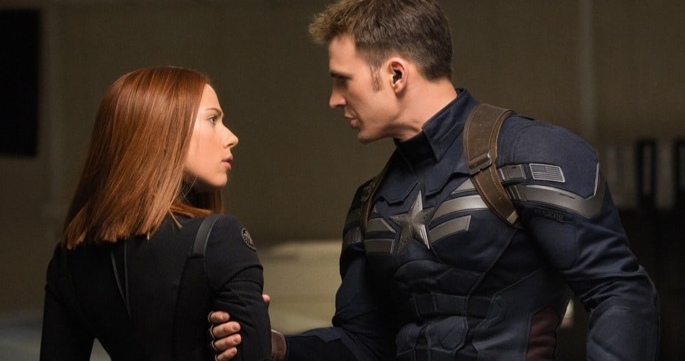 Captain America holding Black Widow by the arm as they look at each other intensely.