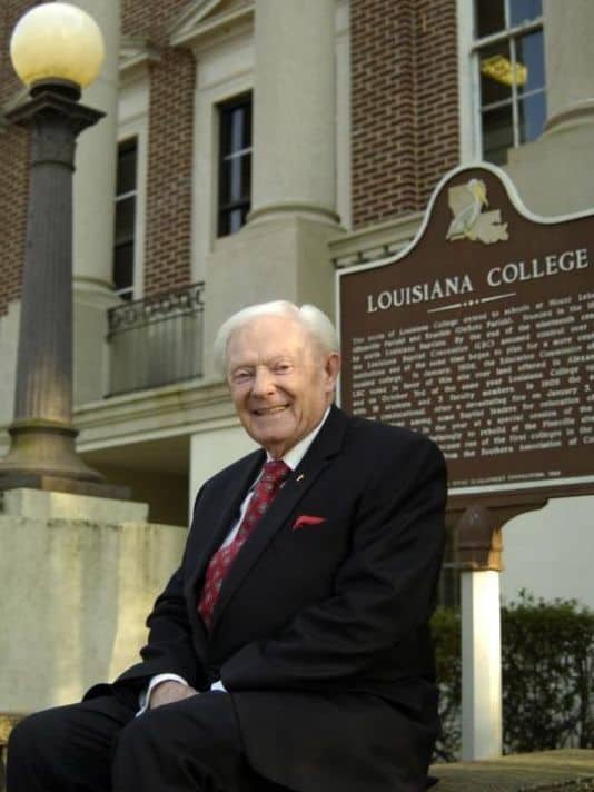 Tommy French sitting in front of the Louisiana College administration building