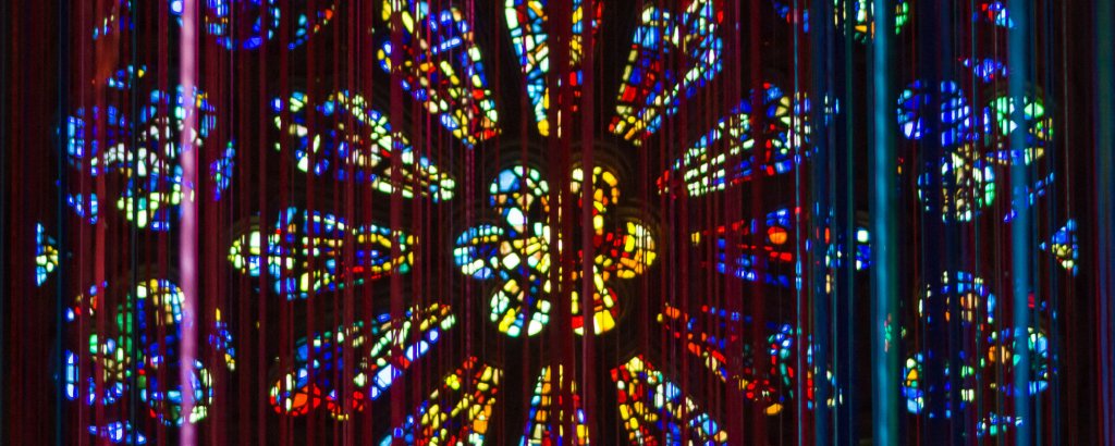An art installation hanging in front of the Rose Window at Grace Cathedral in San Francisco.