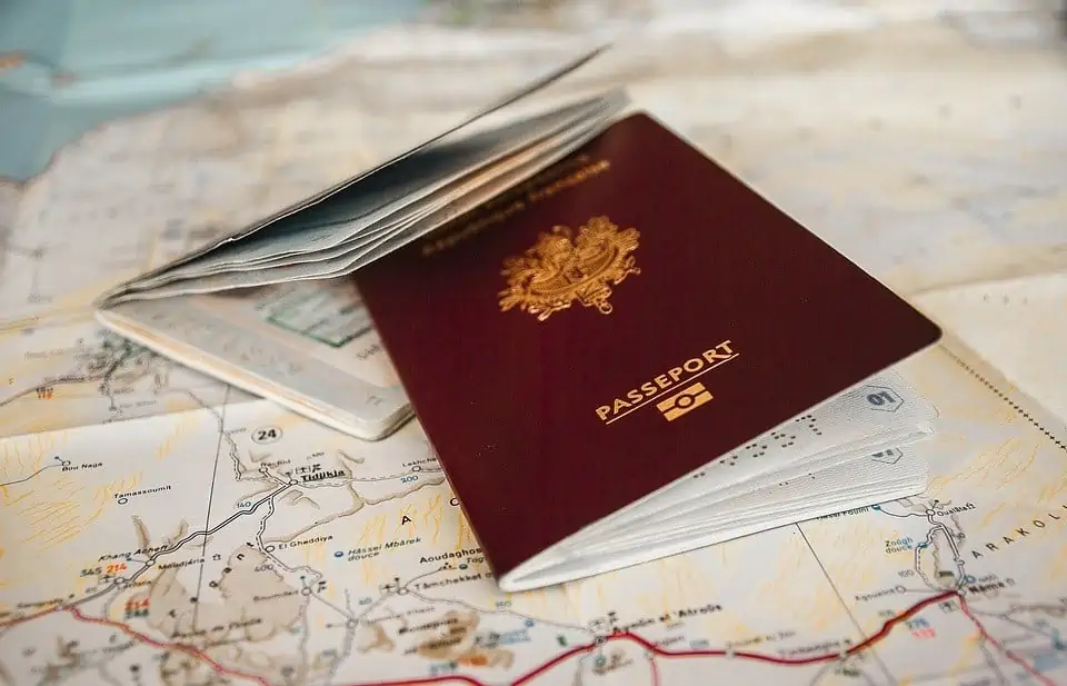 A burgundy passport is shown laying on a map.