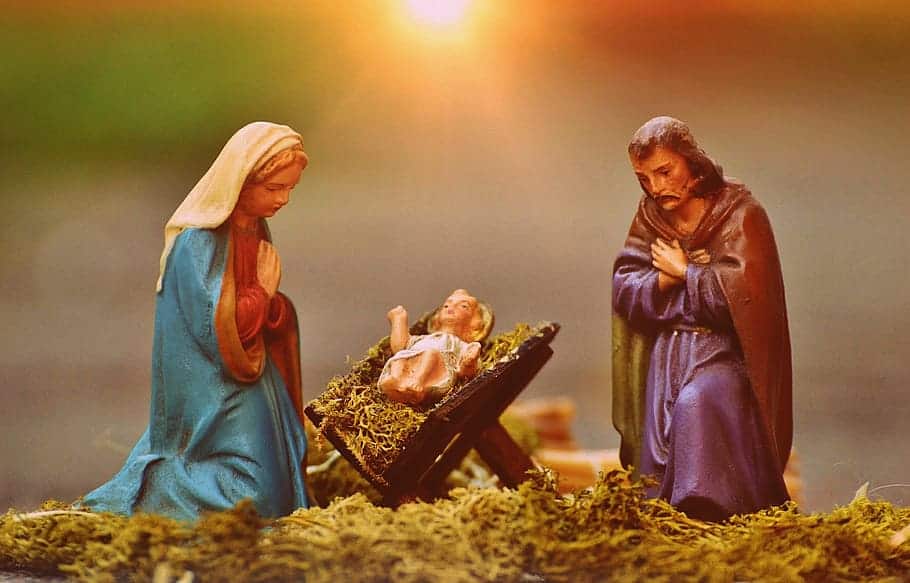 Figurines of Mary, Joseph and baby Jesus are shown in soft light.