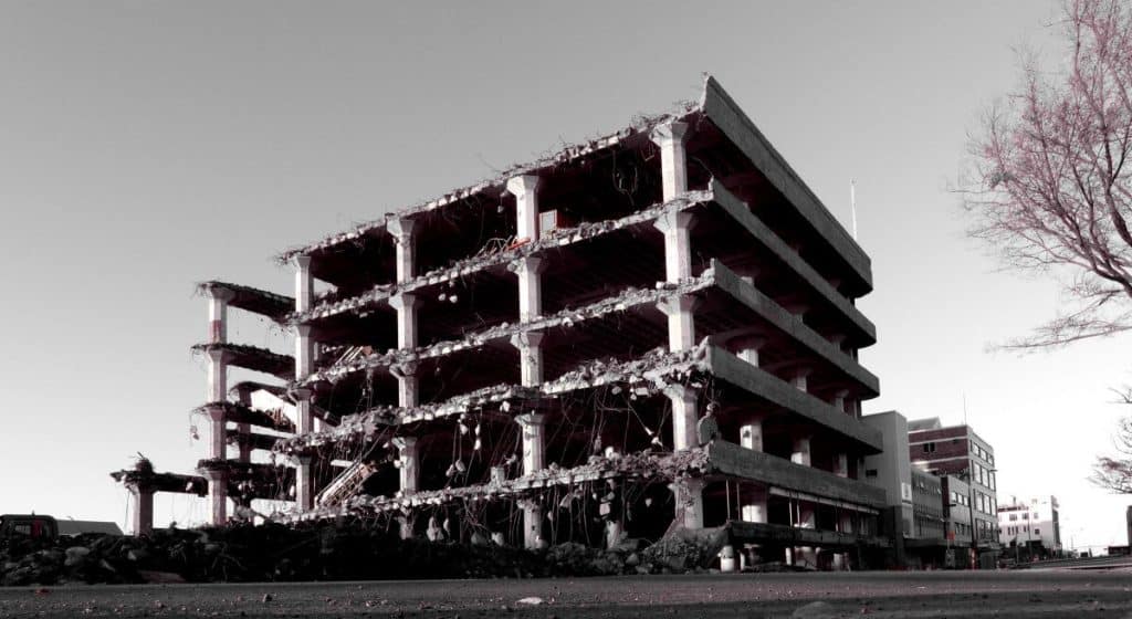A partially deconstructed parking structure with the the front missing, is shown in black and white.