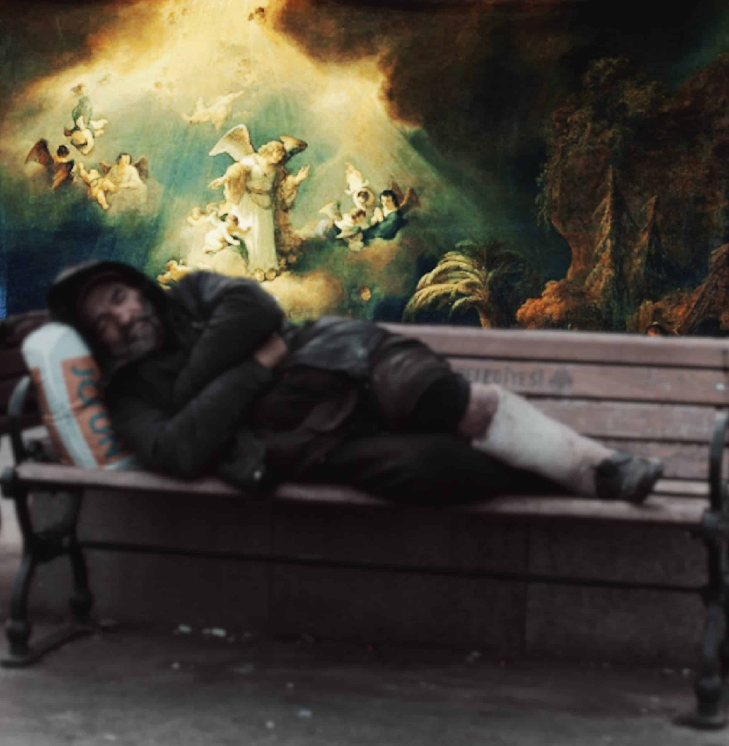 Image shows a man sleeping in the rough on an outdoor bench with a vibrant angelic scene behind him.