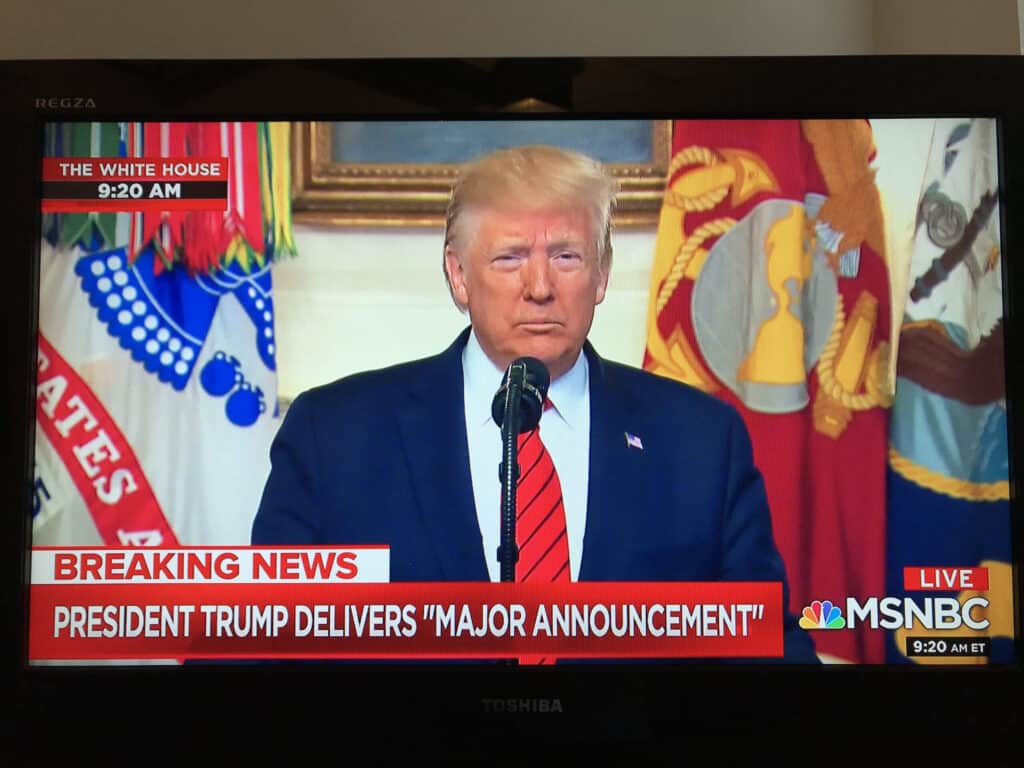 A screen shot from MSNBC shows former President Trump at a microphone.