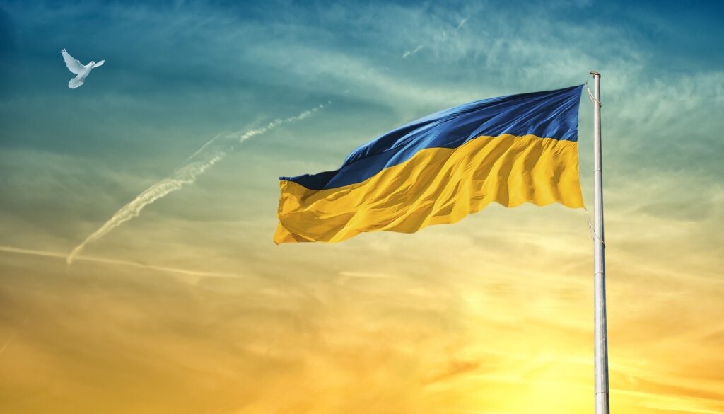 Ukrainian flag against the sky with a dove