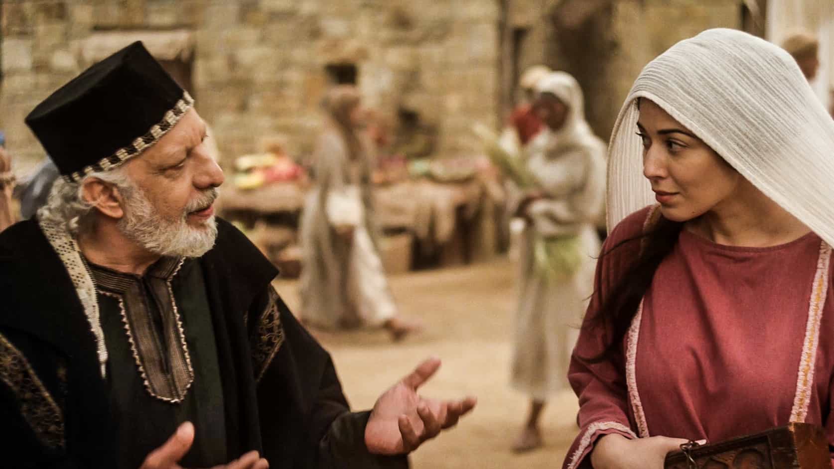 a man and women in middle eastern costume are opposite each other and in conversation