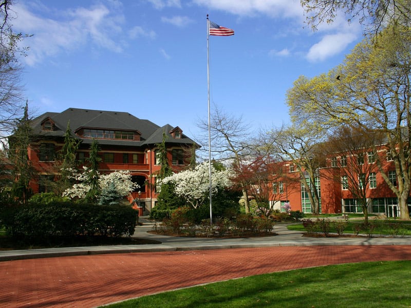 Red brick buildings of Seattle Pacific University are shown from a distance.