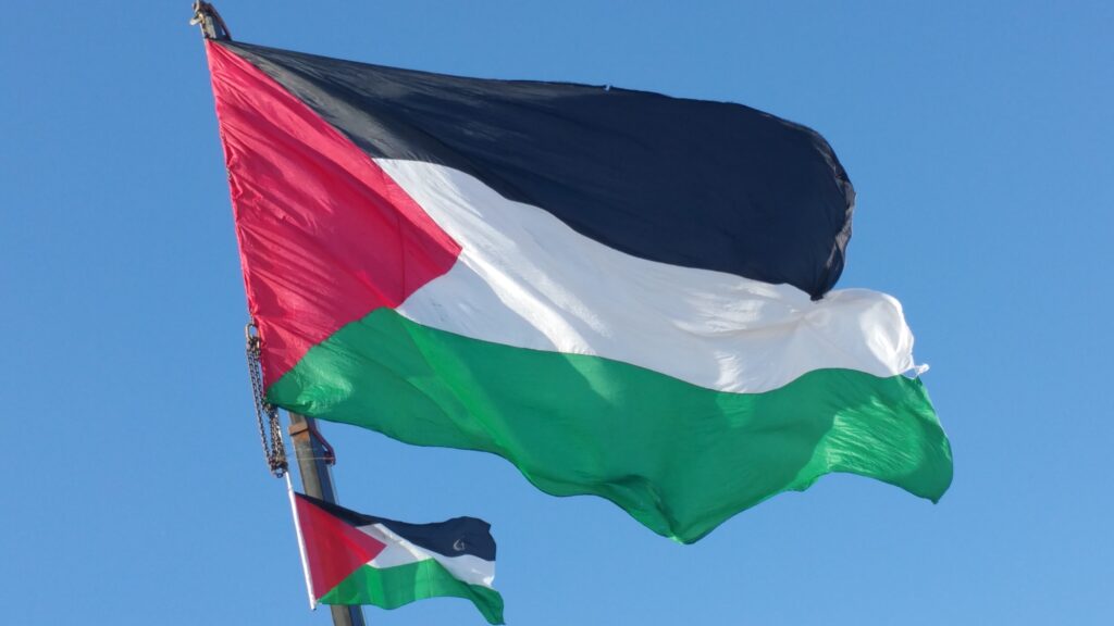 The flag of Palestine, seen close up, waves in the breeze.