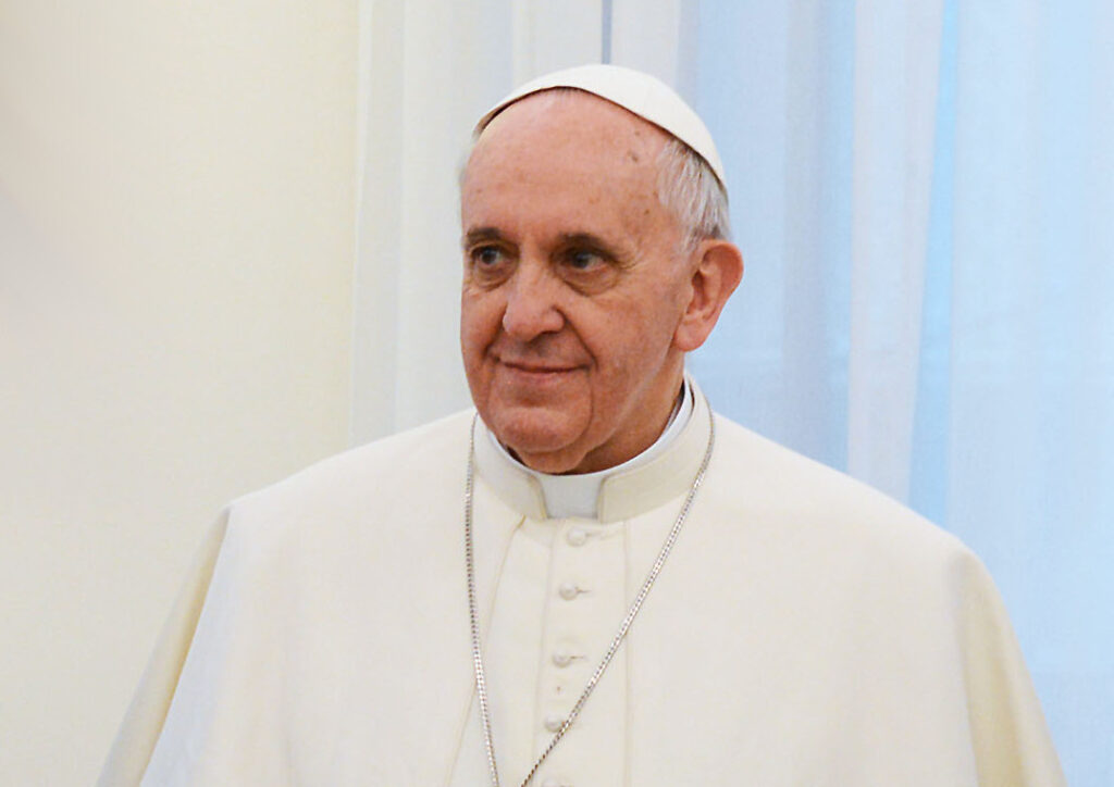 Pope Francis is shown dressed in white papal garments.