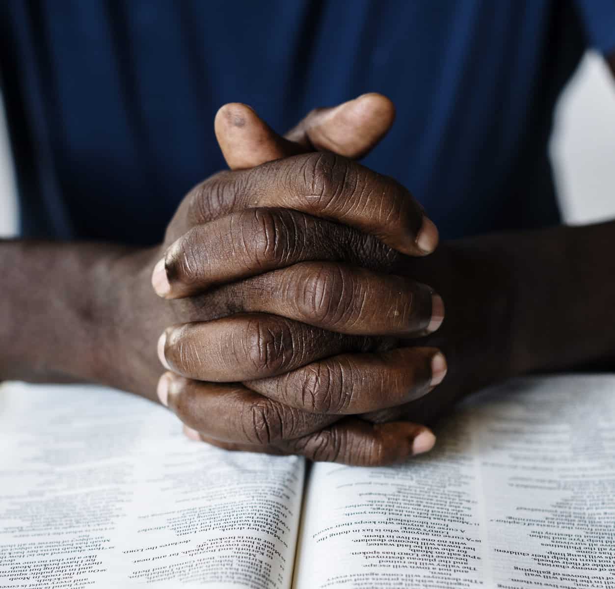 african-american-male-hands-resting-on-an-open-bible
