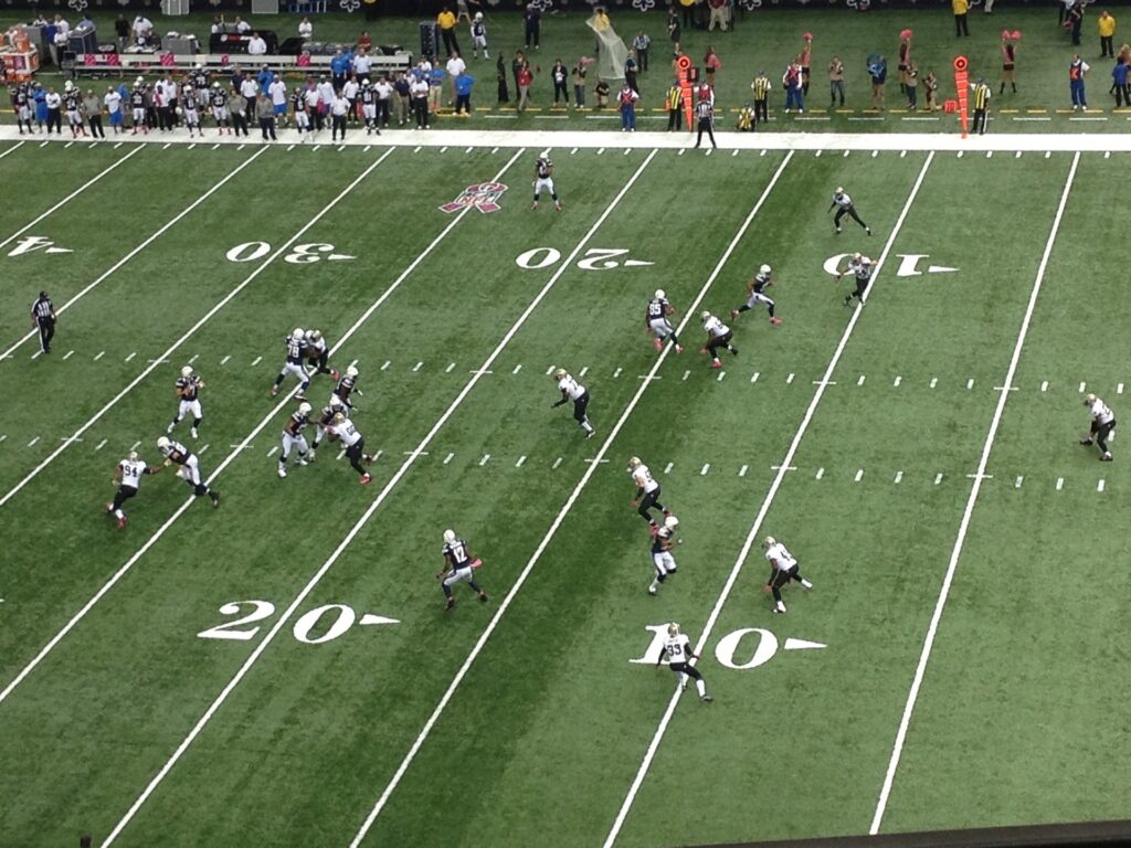 Image shows football players on a football field from a distance.