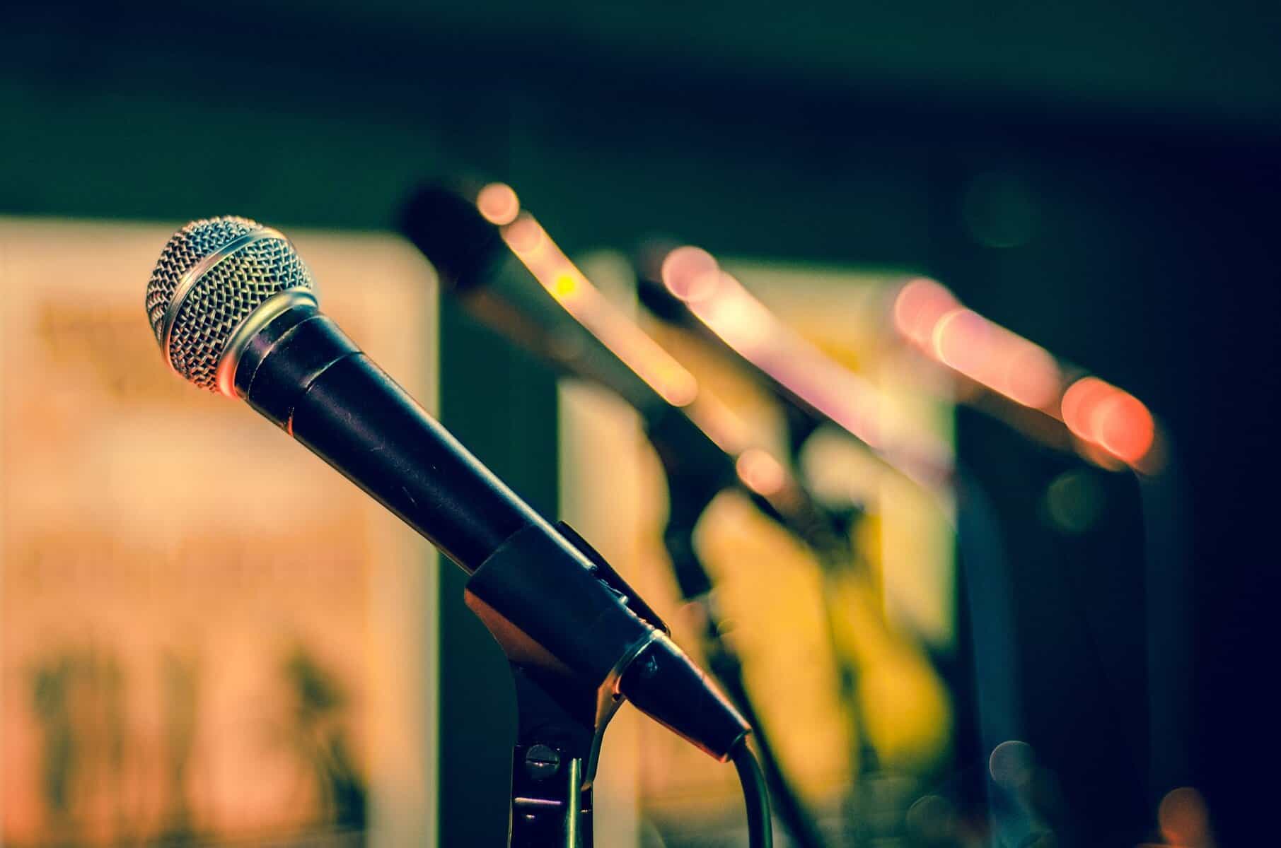 Microphones are shown lined up and on stands with the closest one being in focus.