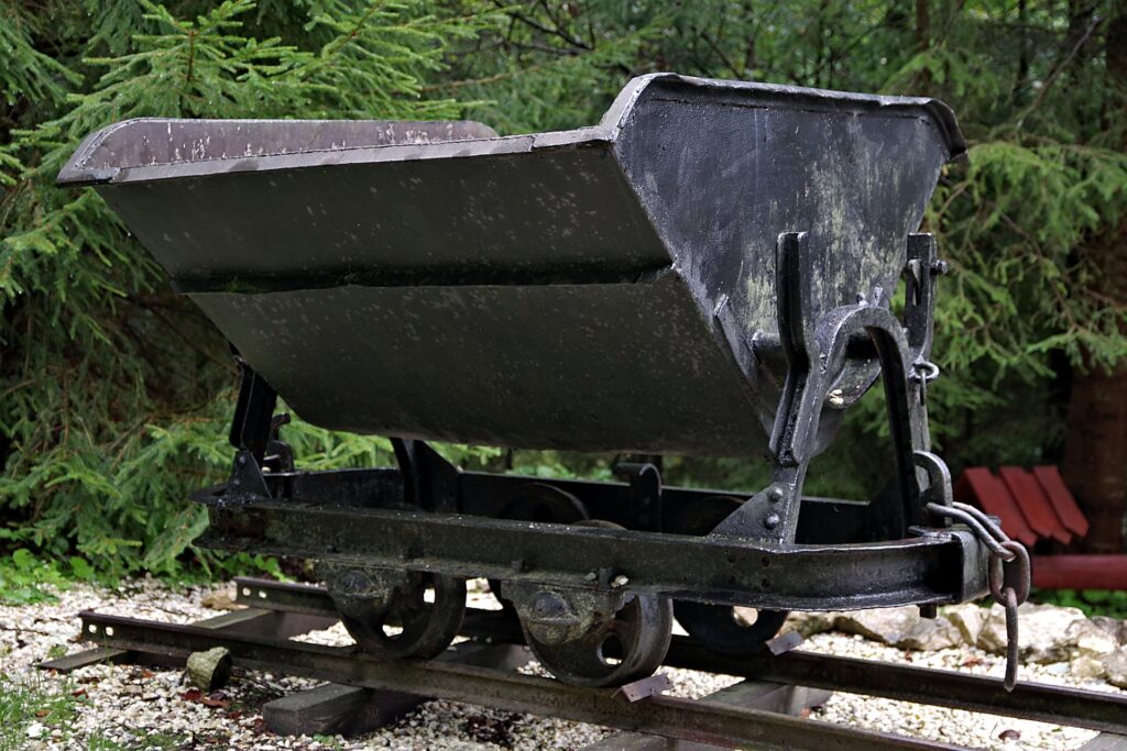 An old coal car is shown on a section of tracks.