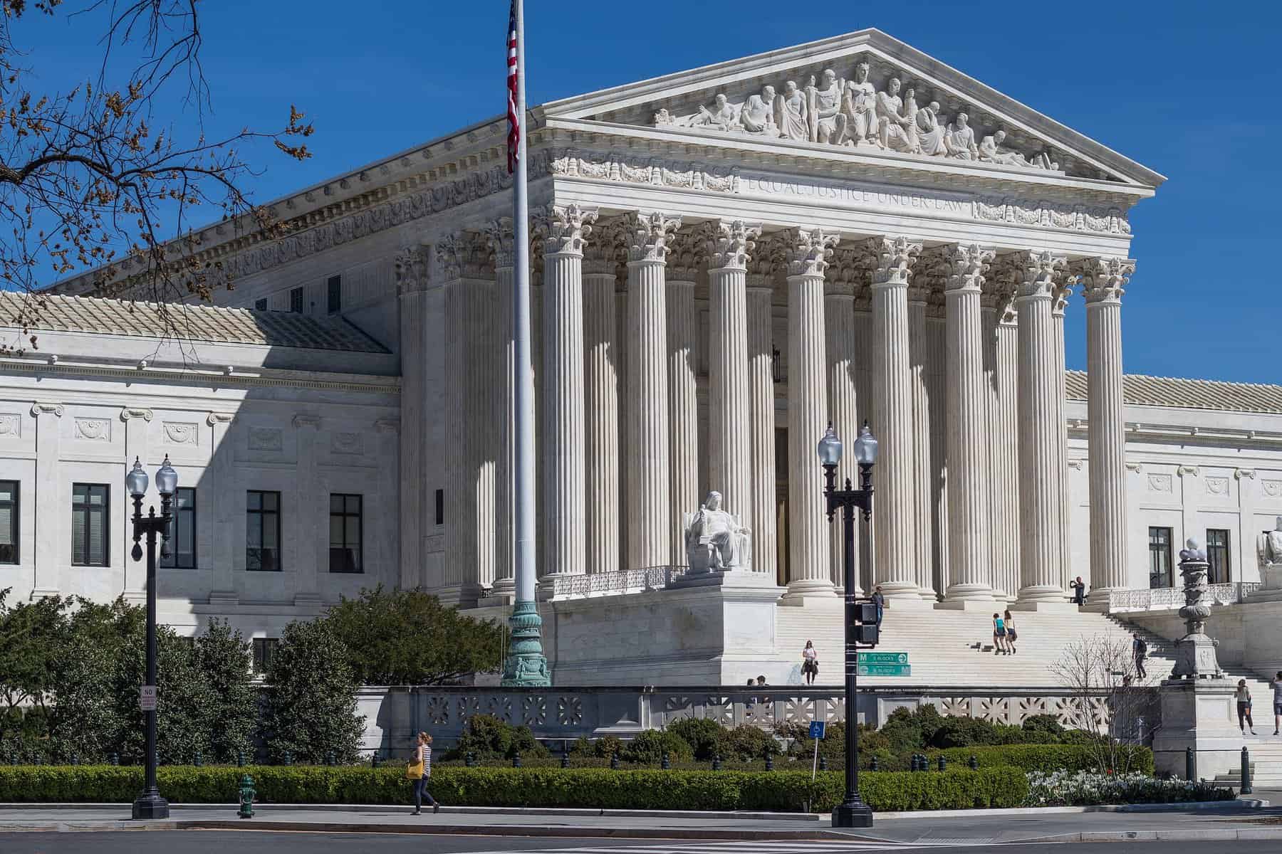 The facade of the Supreme court is seen at an angle from the street.