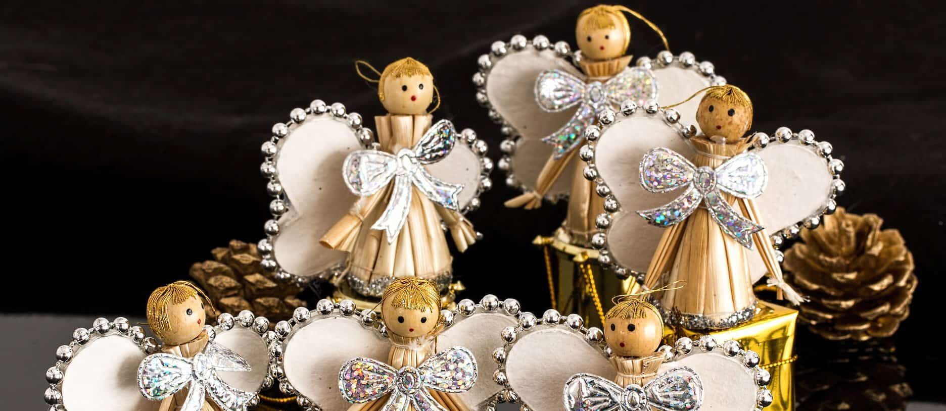 Old fashioned wooden clothespins are seen made into angels with paper wings and embellishments.