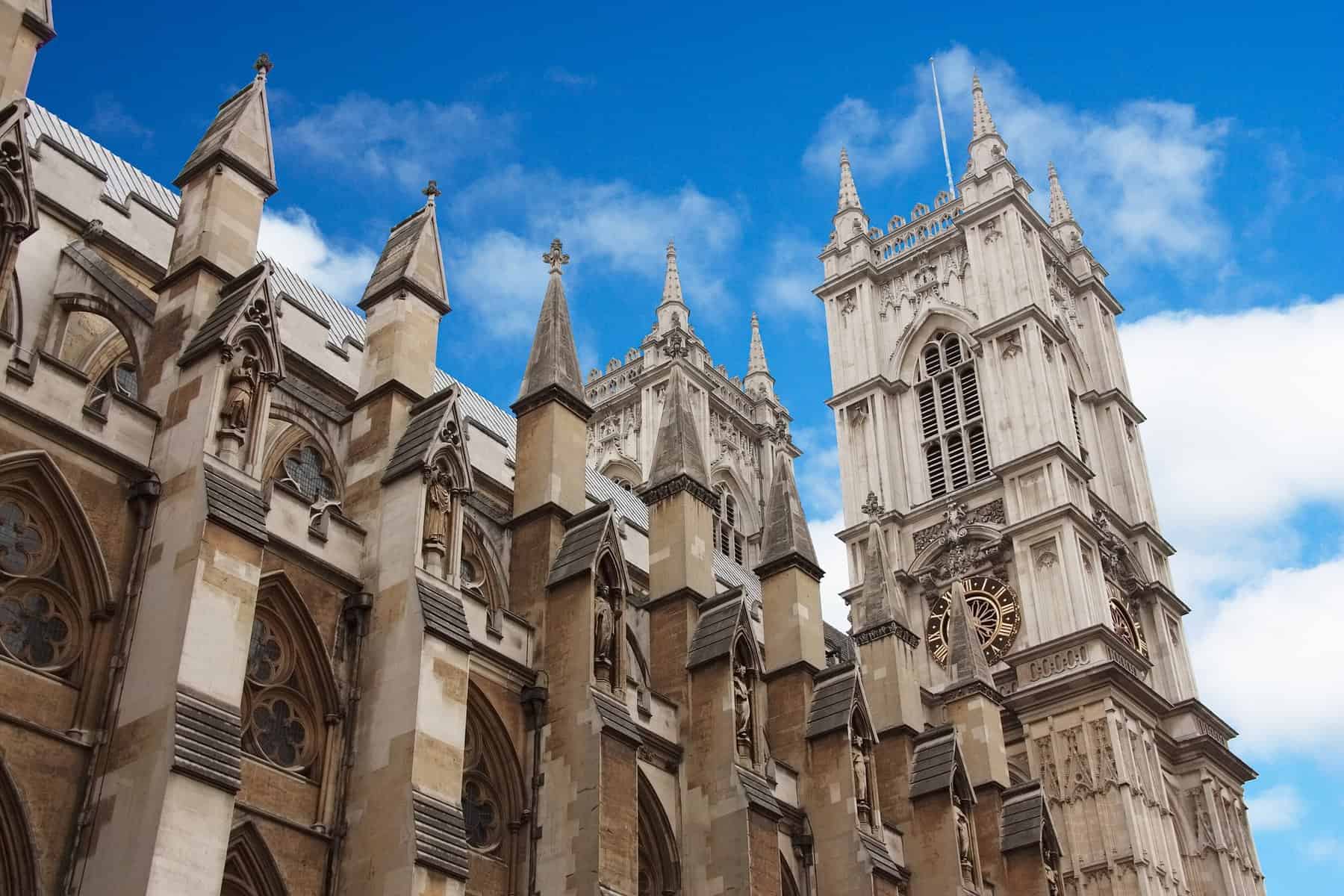 The upper portion of Westminster Abbey, including tower, is seen from the street below.