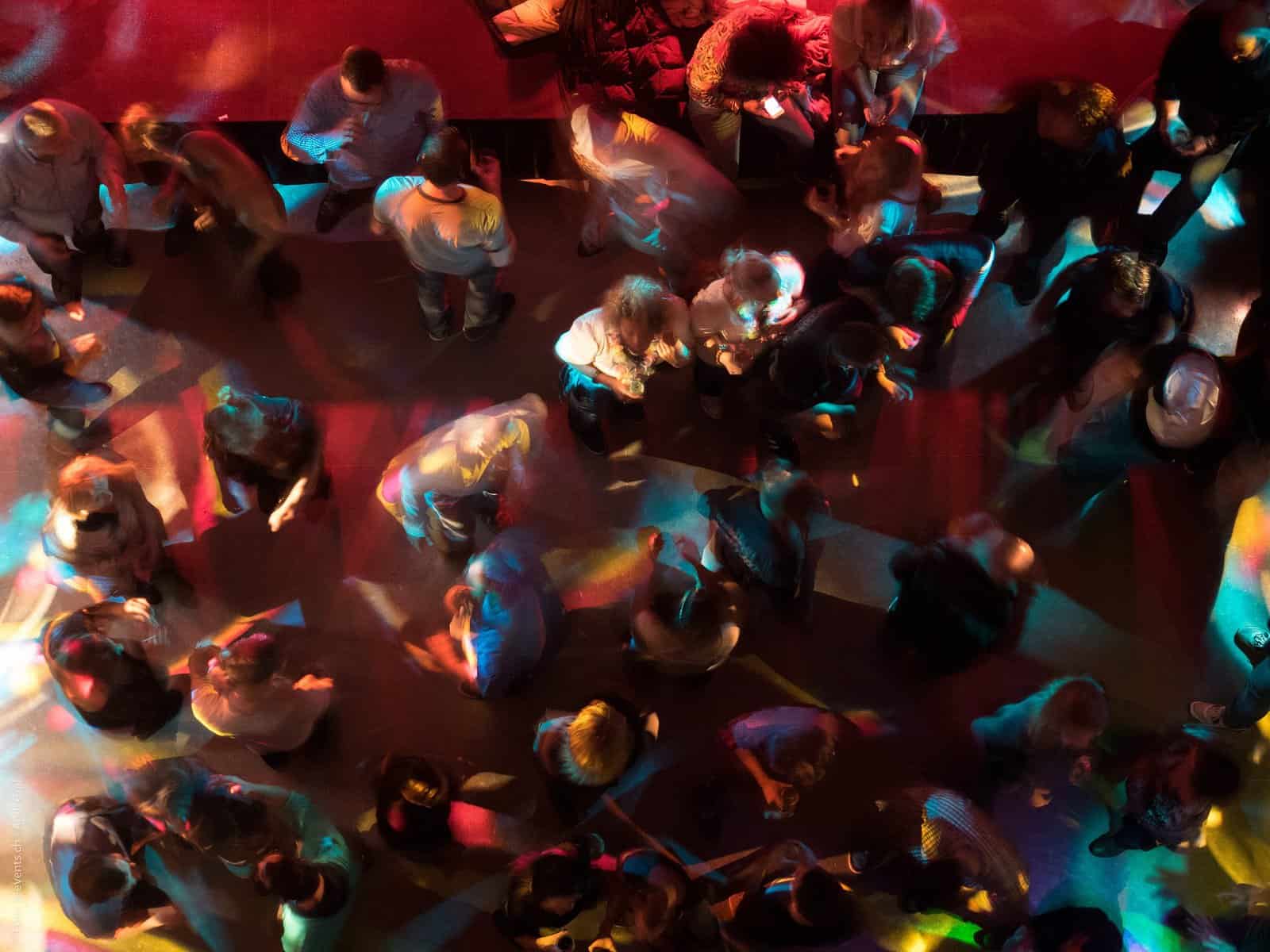 People gathered at an event are seen from above and are blurred in an abstract manner.