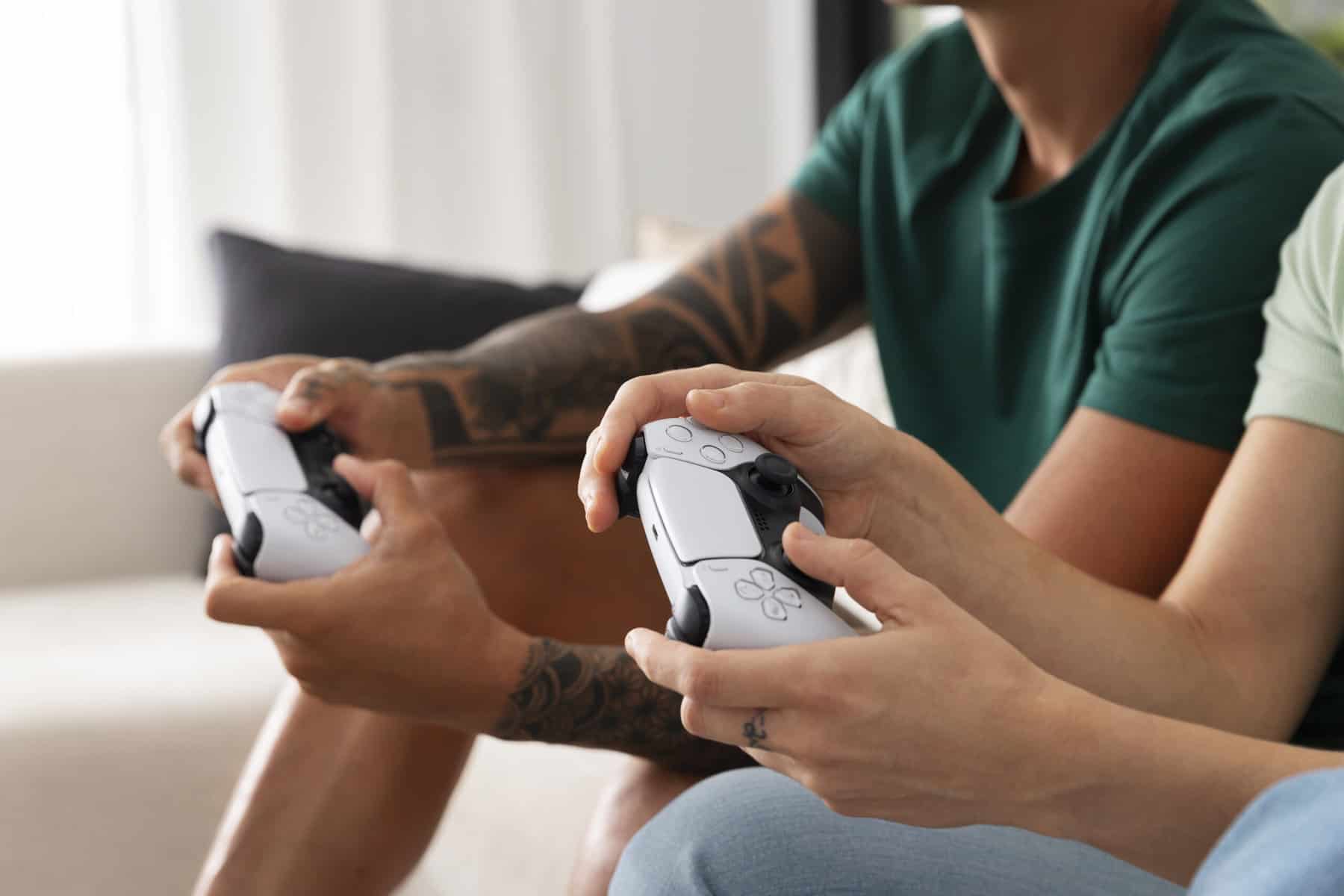 Two people's hands are seen holding game controllers.