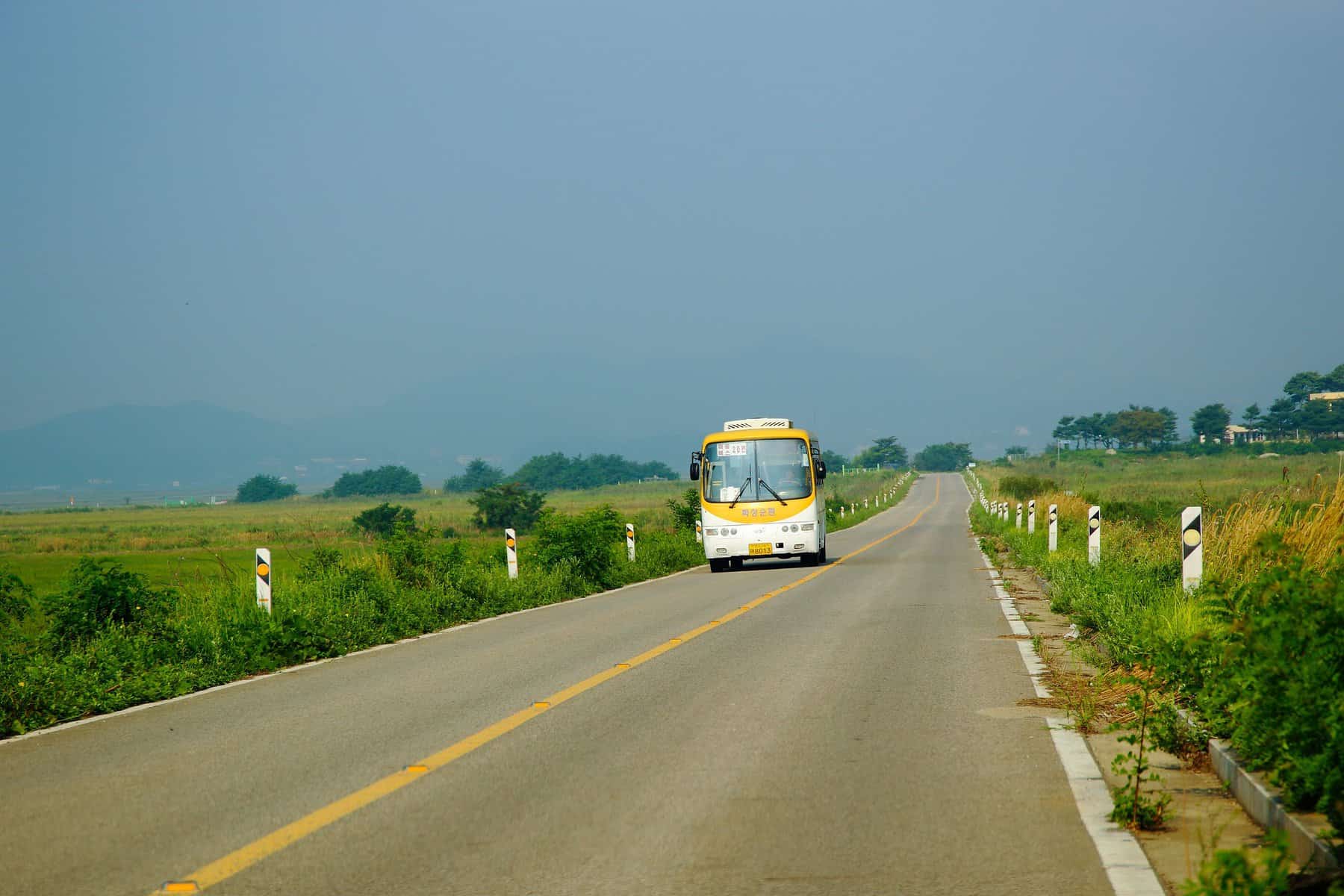 A bus is seen coming down a road toward the camera from a distance.
