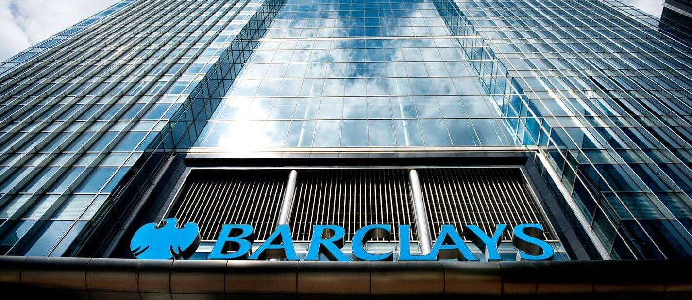 The reflective front of a Barclays building is shown.
