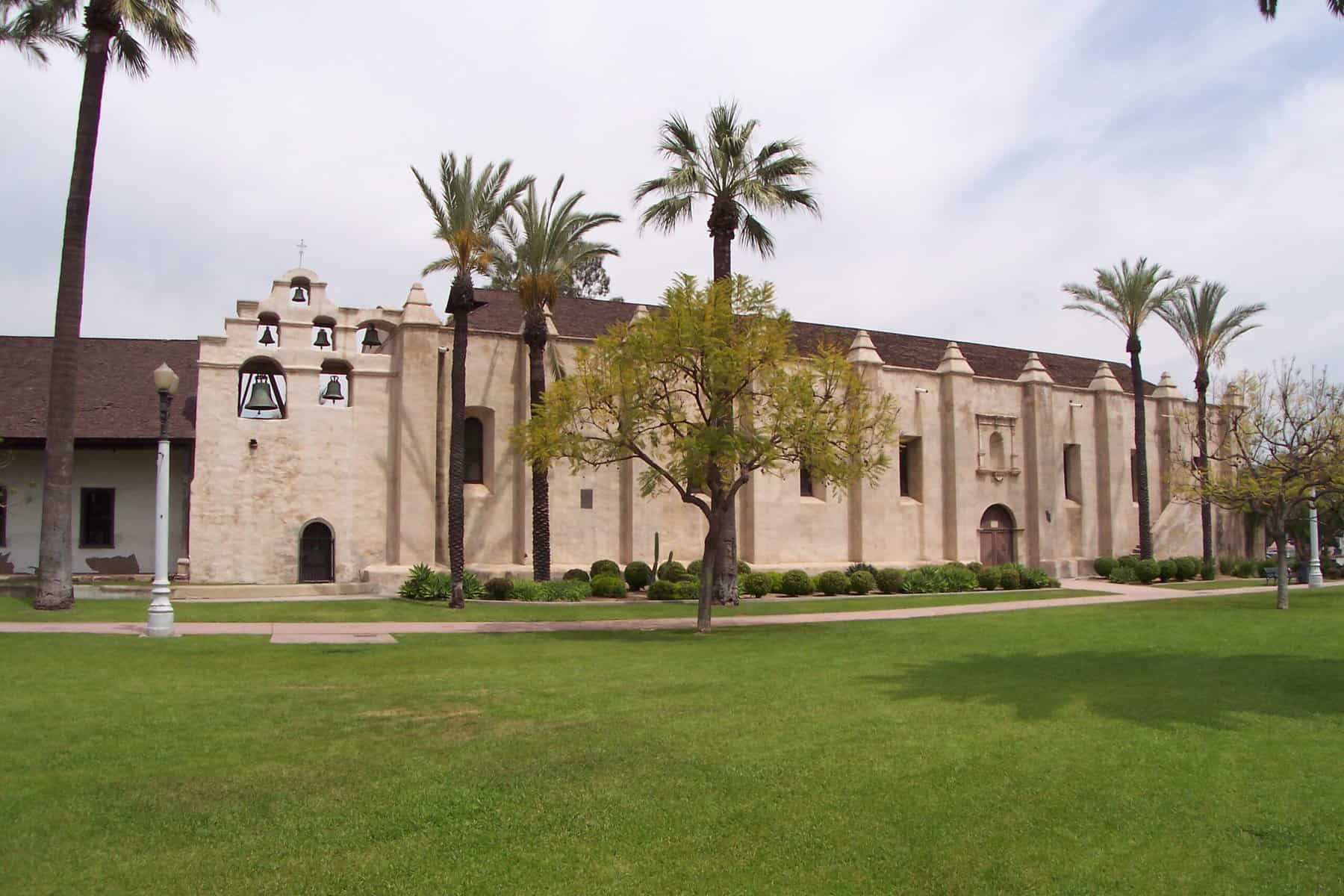 Mission San Gabriel in California is shown from across the grass.