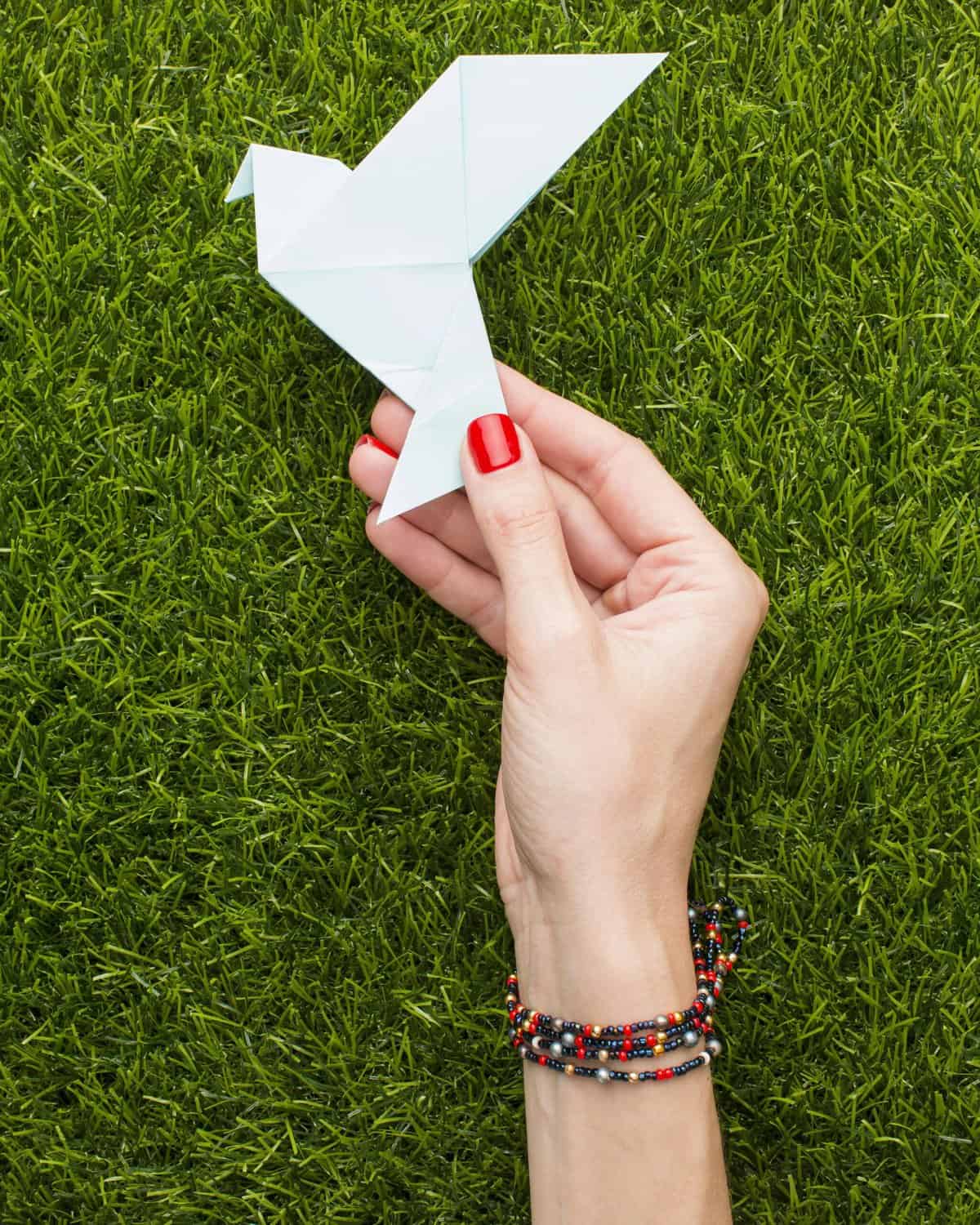 top-view-hand-holding-a white paper crane