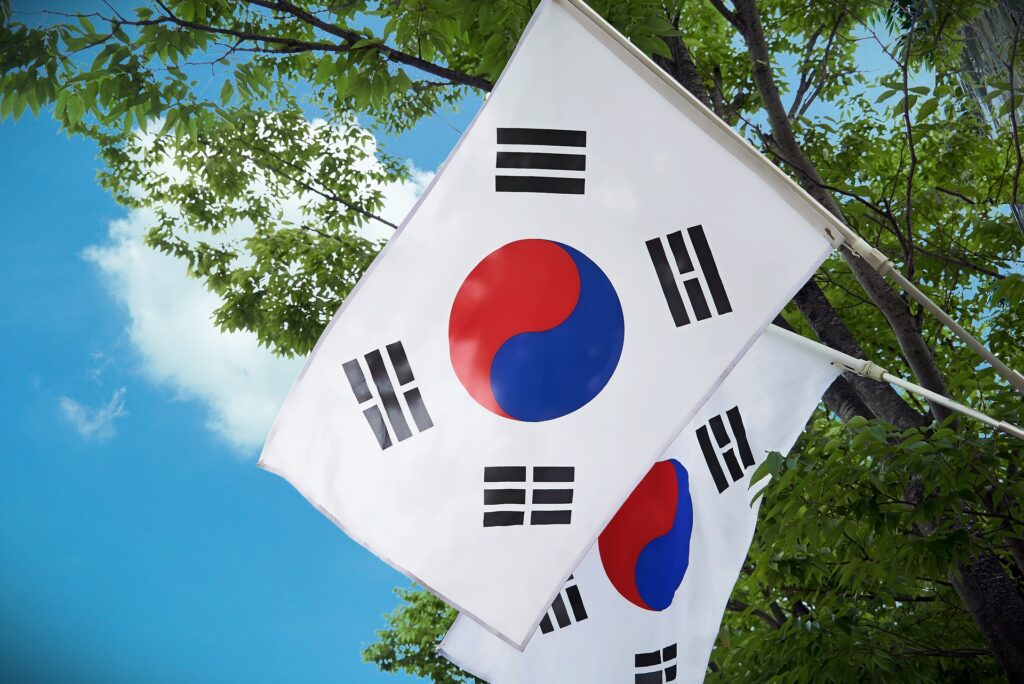 Two South Korean flags are shown one behind the other on flagpoles.