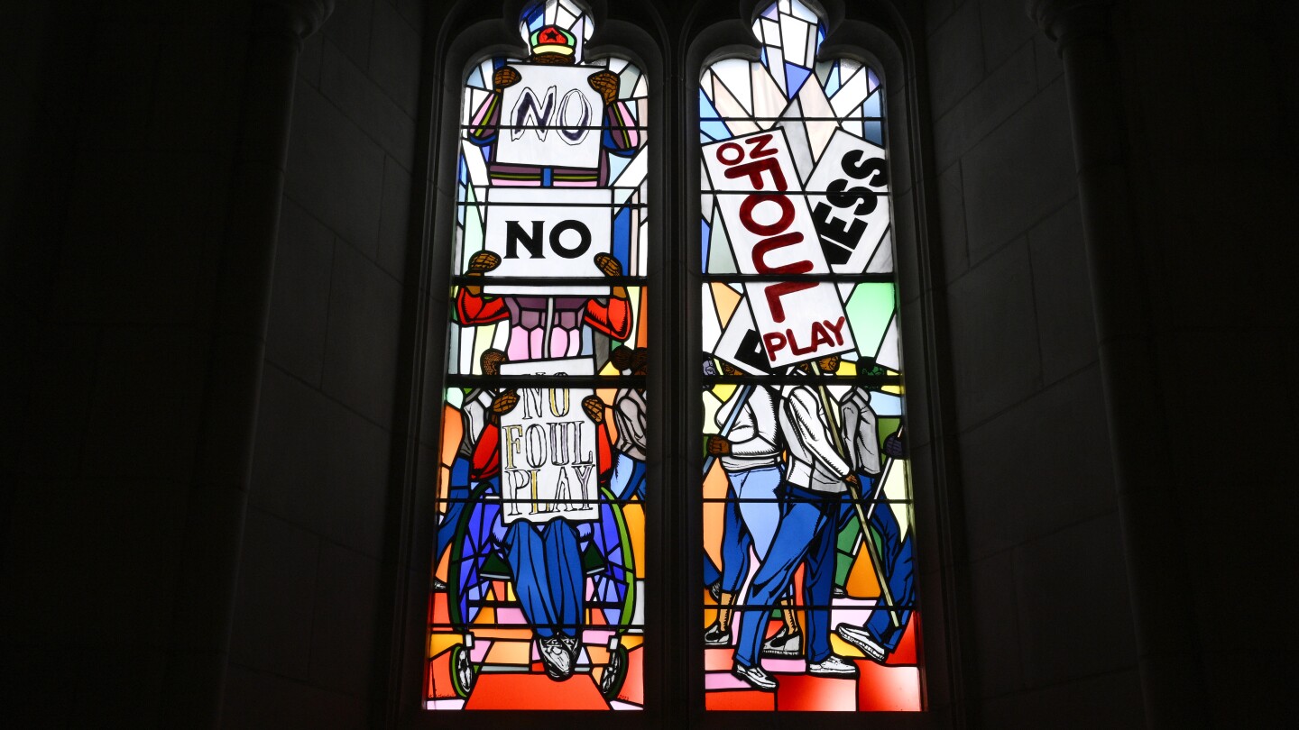 Stained glass windows at the National Cathedral are seen from inside a dark building.