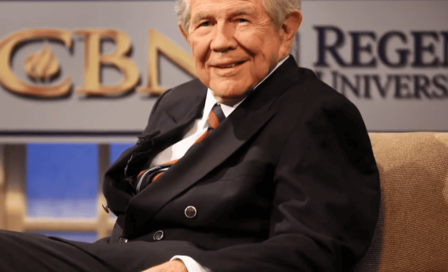 A screenshot of Pat Robertson shows him seated and between the logos of CBN and Regent University, both of which he founded.