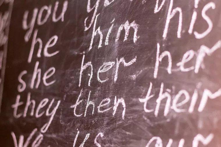A chalk board with pronouns written on it.