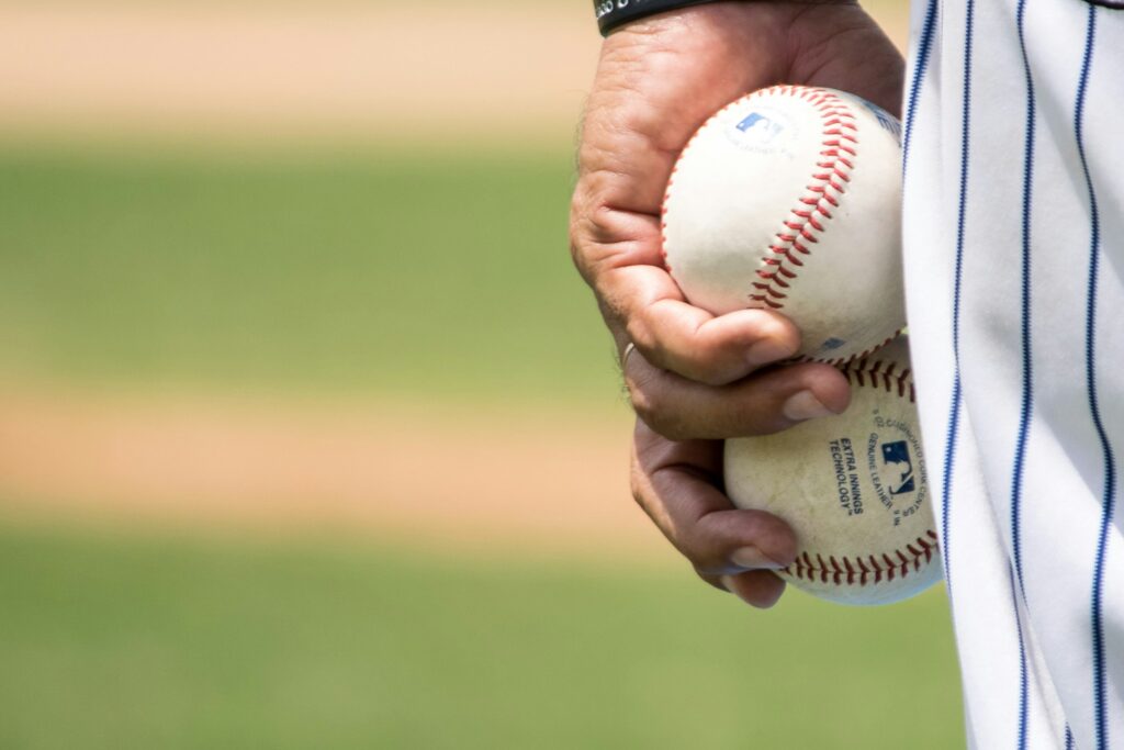 How D.J. Iverson's Padres passion fuels family and faith A man's hand is shown closeup against his uniformed leg holding two baseballs at his side.