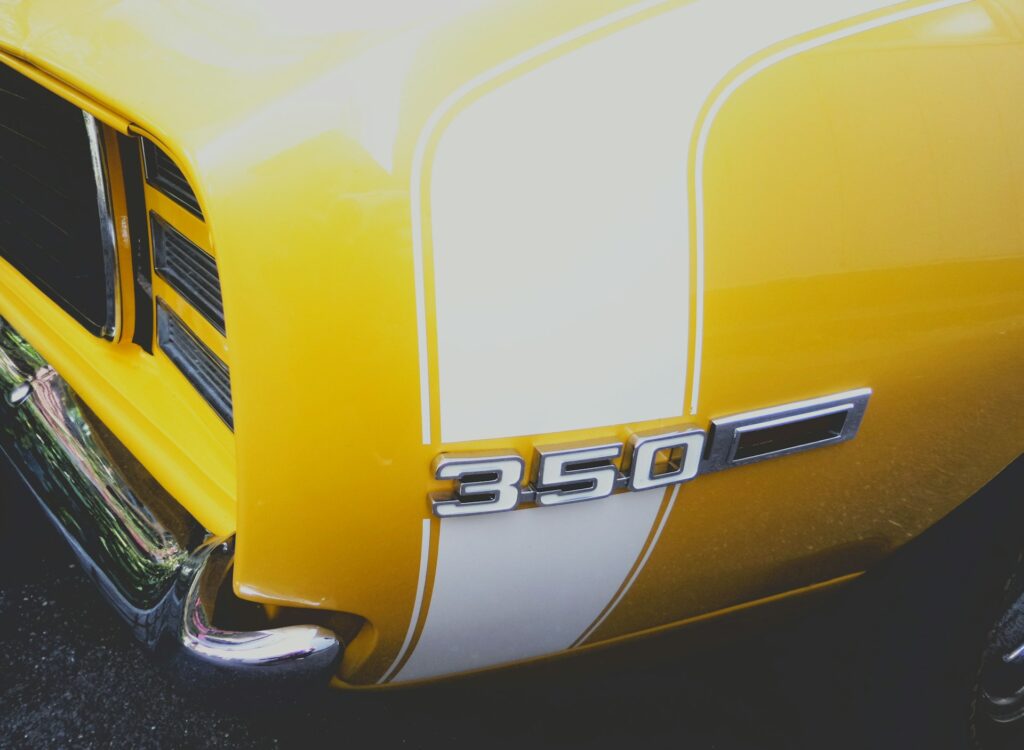 Rear quarter panel of a yellow muscle car.