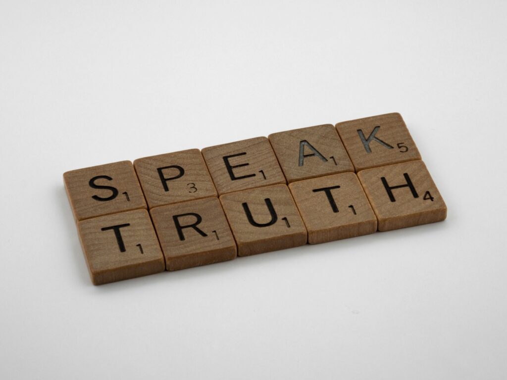 Republican Epstein survivors confront Trumpโs โDemocrat hoaxโ accusation Scrabble tiles say Speak Truth.