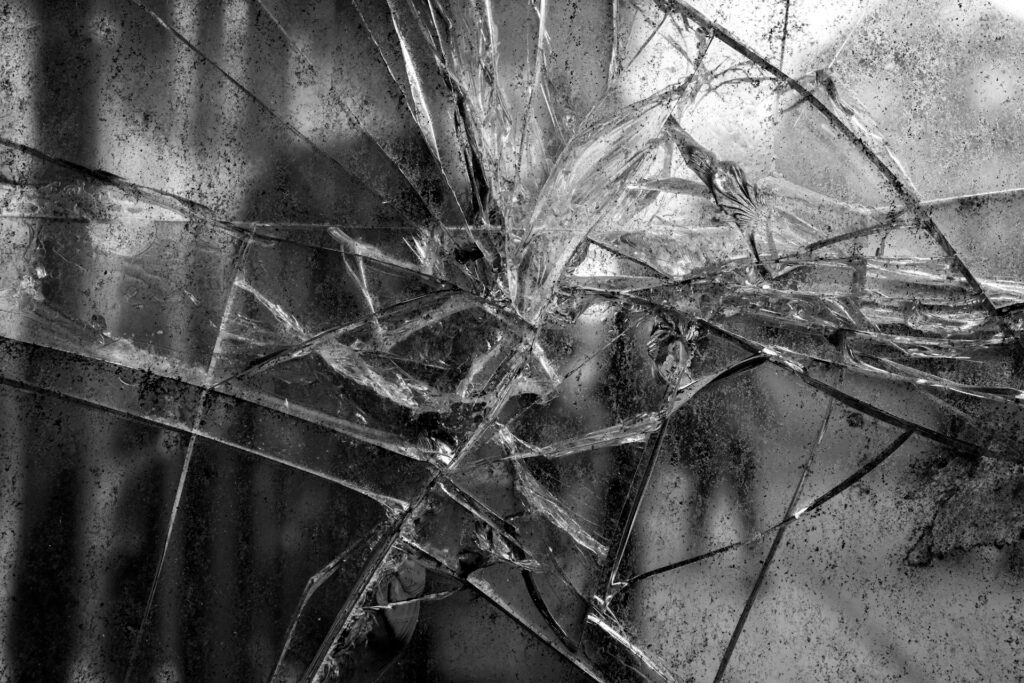 Faith and Fractures: Inside the religious coalition shaping conservative politics Black and white grungy photo of a badly fractured mirror.