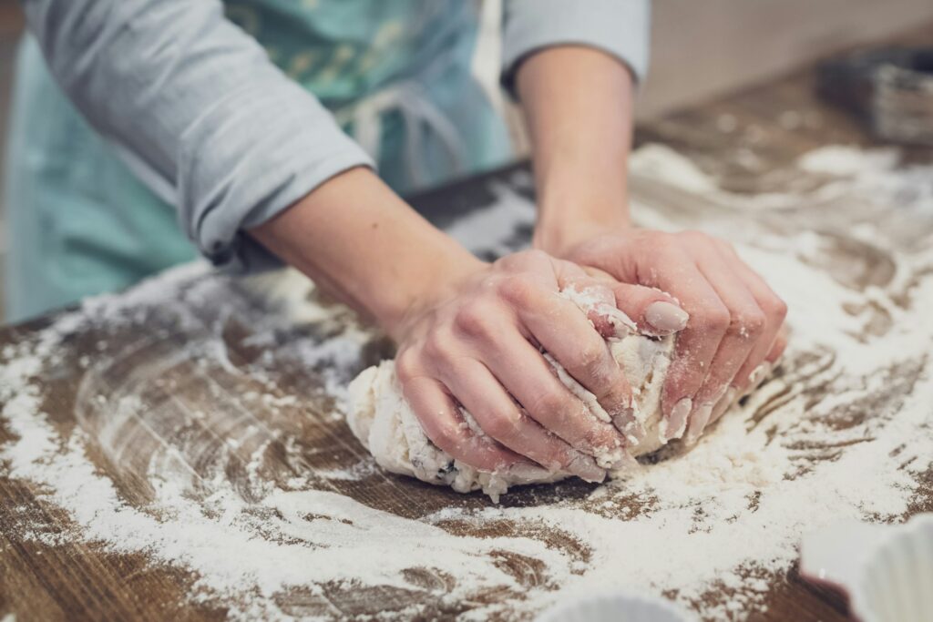 Inside the Tradwife movement: Faith, femininity, and far-right ideas A woman with manicured nails kneading dough.