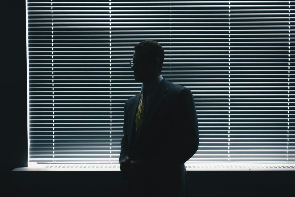 A man in shadow in front of a window.
