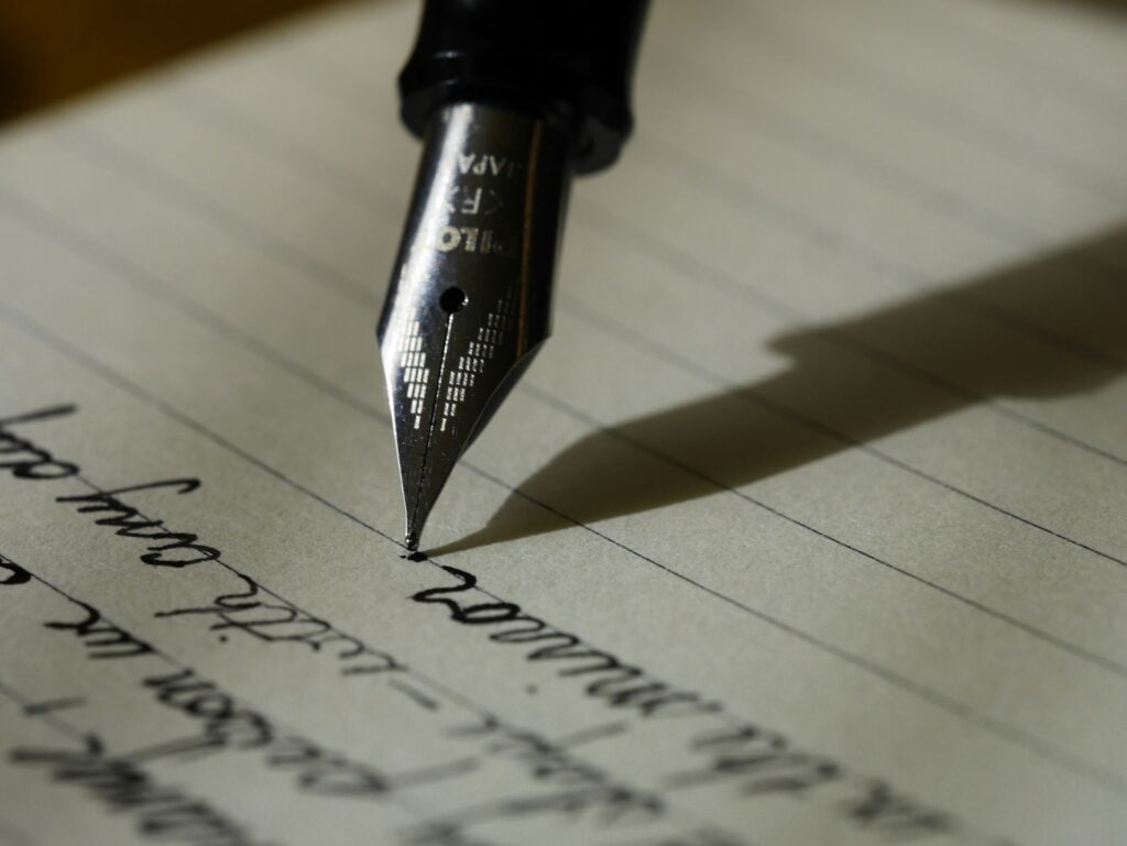 A calligraphy pen is shown poised to continue writing script.