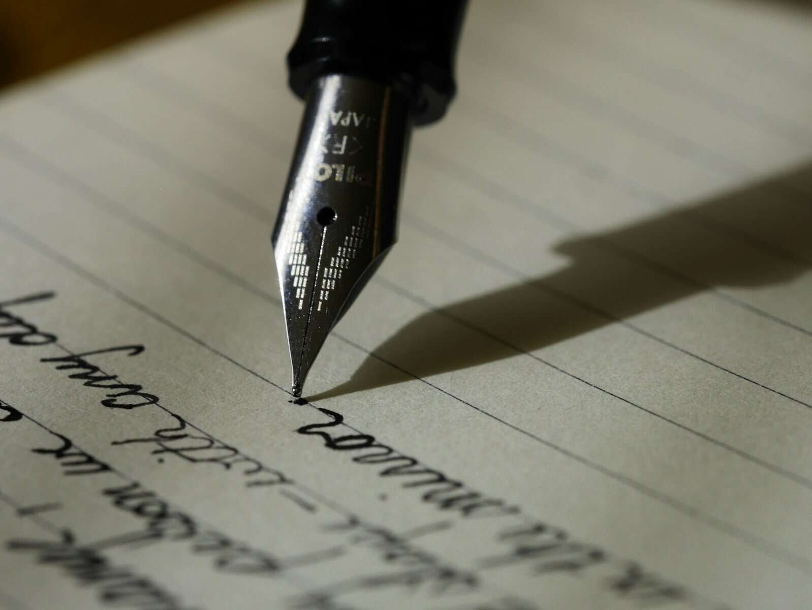 A calligraphy pen is shown poised to continue writing script.