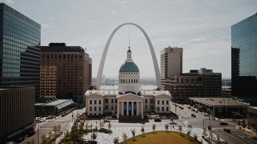 Aerial view of historic Notre Dame Cathedral in St. Louis with the Gateway Arch towering in the background.