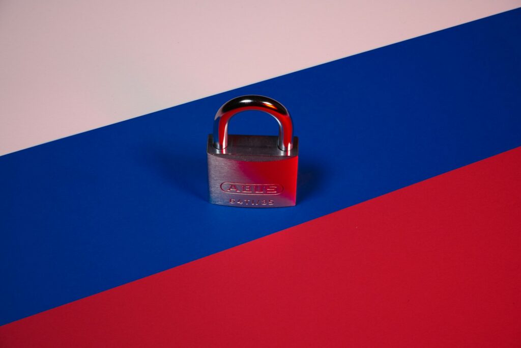 How Russia’s courts are silencing unregistered Baptist congregations Russian flag with a closed padlock on top.