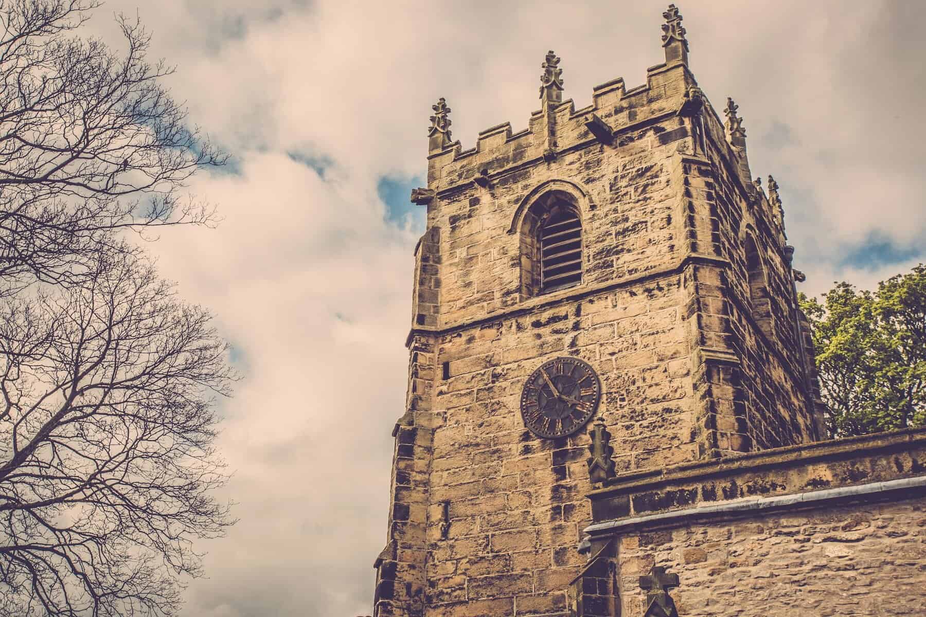 Tower of an ancient brown stone church.