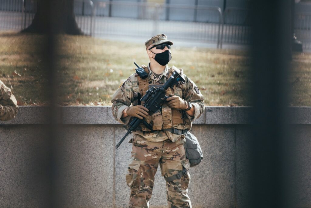 A National Guardsman seen between fence bars.