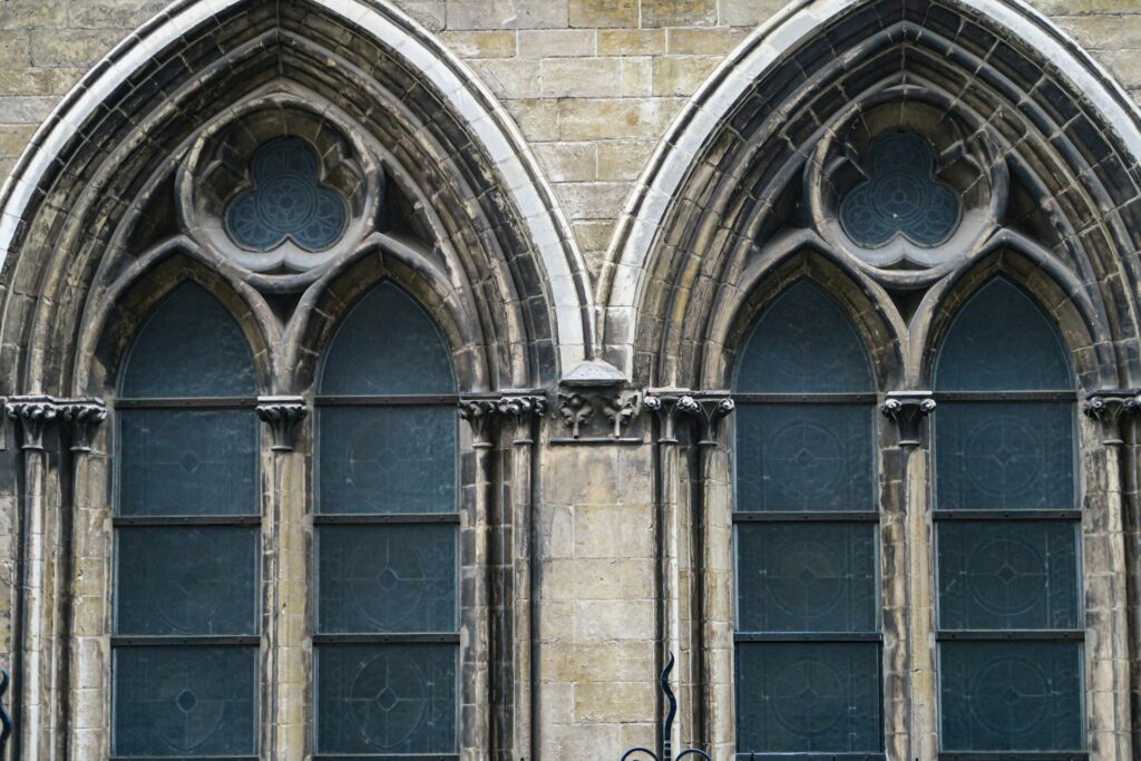 Episcopal Church Protests: Clergy take faith to the streets after ICE shooting A pair of large church stained glass windows from the outside.