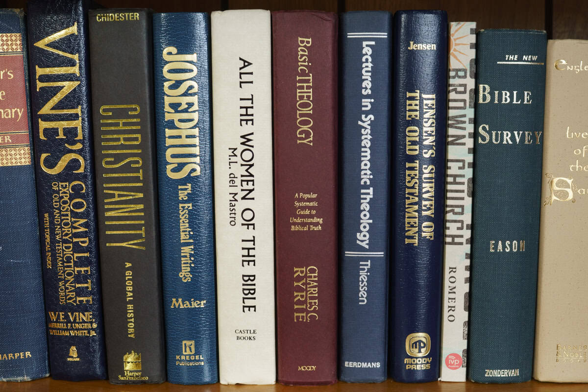 A row of theology books on a shelf.
