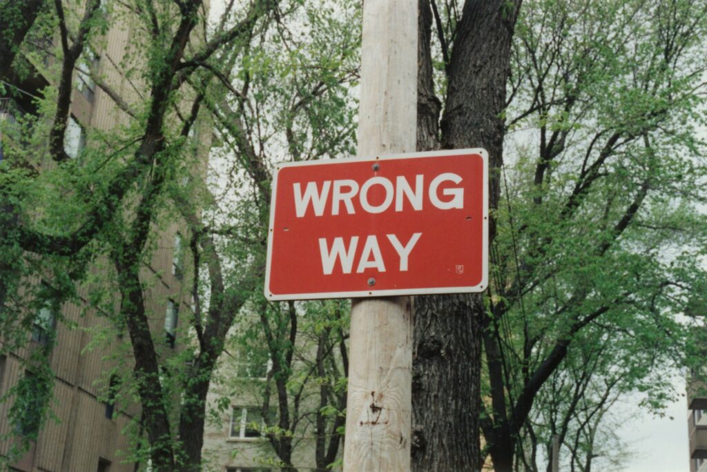 A red wrong way sign on a post.