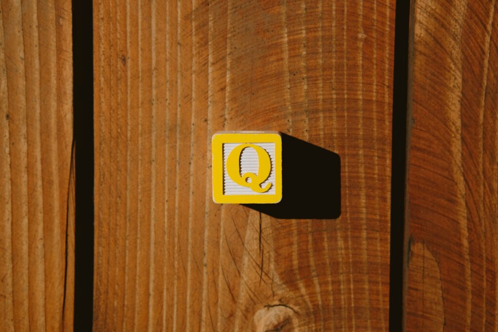 A child's wooden block with a Q on it.