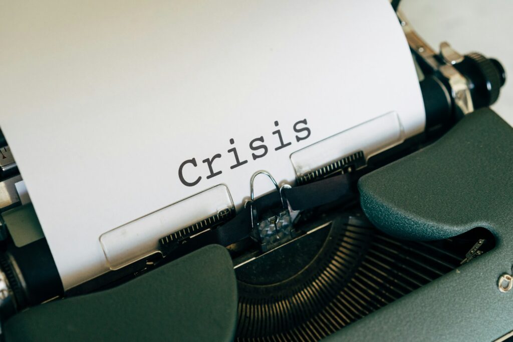 A typewriter with a piece of paper that says "Crisis".